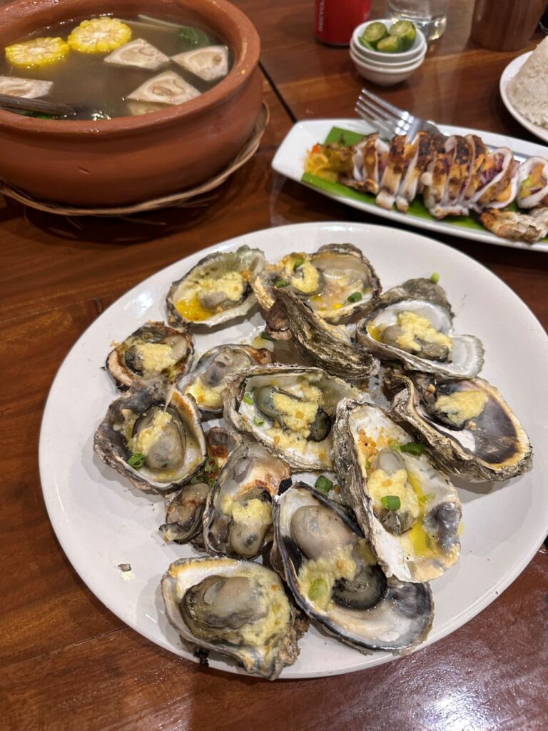 Savoring local favorites in Iloilo—baked talaba, hearty kansi, and perfectly grilled squid.